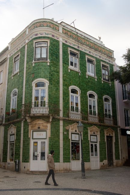 A stunning vintage green-tiled building on a corner in Lagos, exemplifying Portuguese architecture.