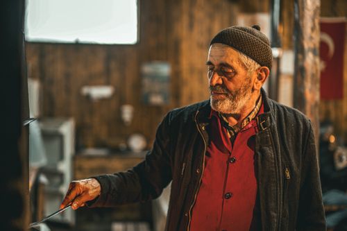 Free Elderly man in rustic setting with warm lighting, portraying heritage and wisdom. Stock Photo