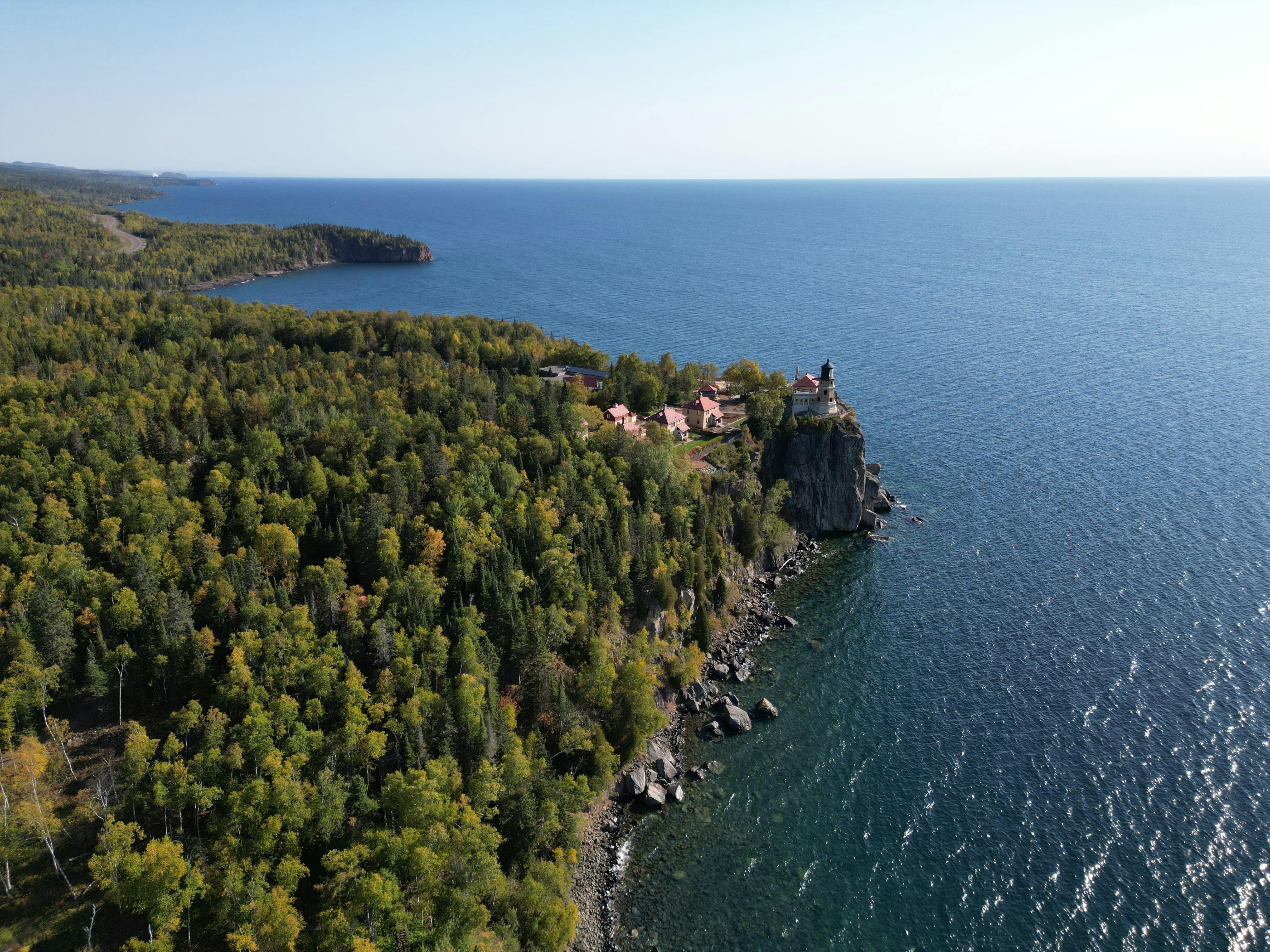 Majestic aerial view of Split Rock Lighthouse on a forested cliff overlooking Lake Superior.