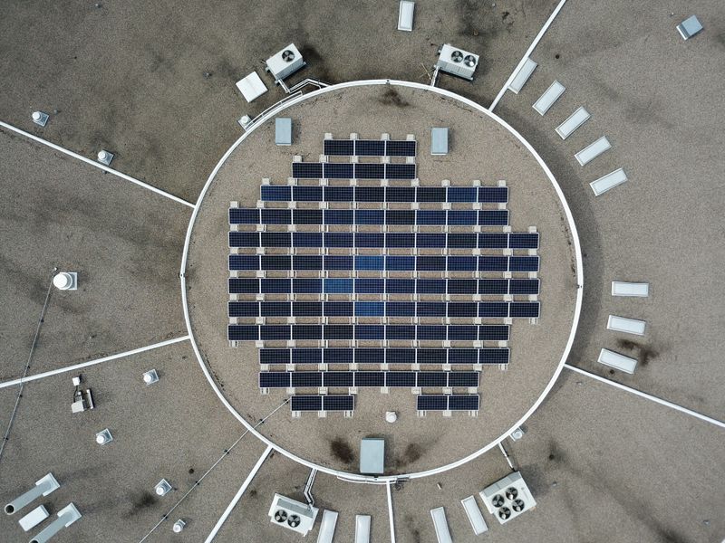Aerial view of a circular solar array surrounded by gravel