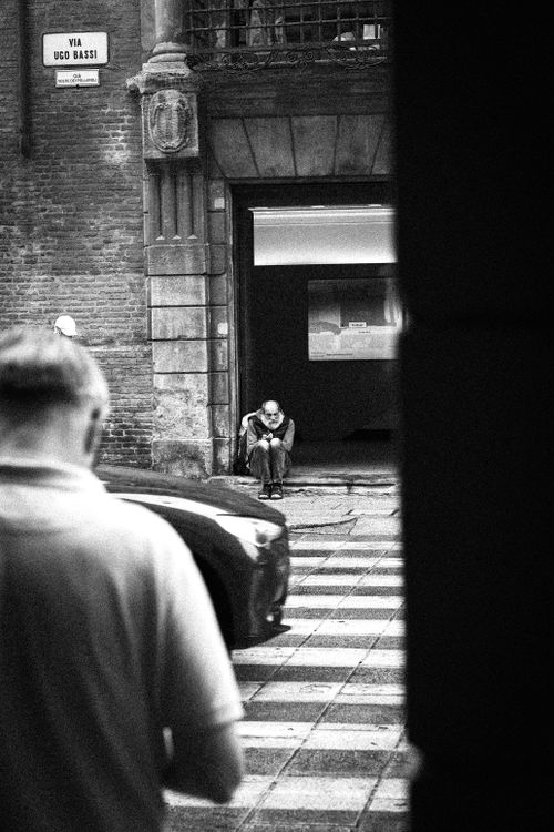 Free Street scene in Bologna showing a contemplative person in urban setting. Stock Photo