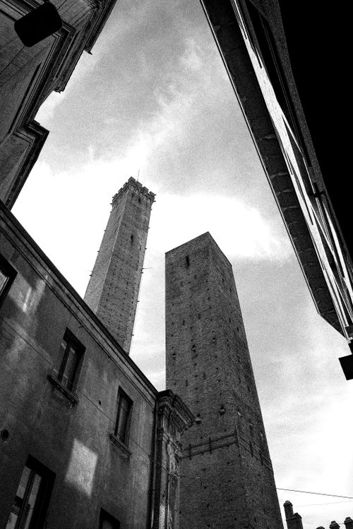 Free Stunning view of Bologna's iconic Asinelli and Garisenda Towers framed by historic architecture. Stock Photo