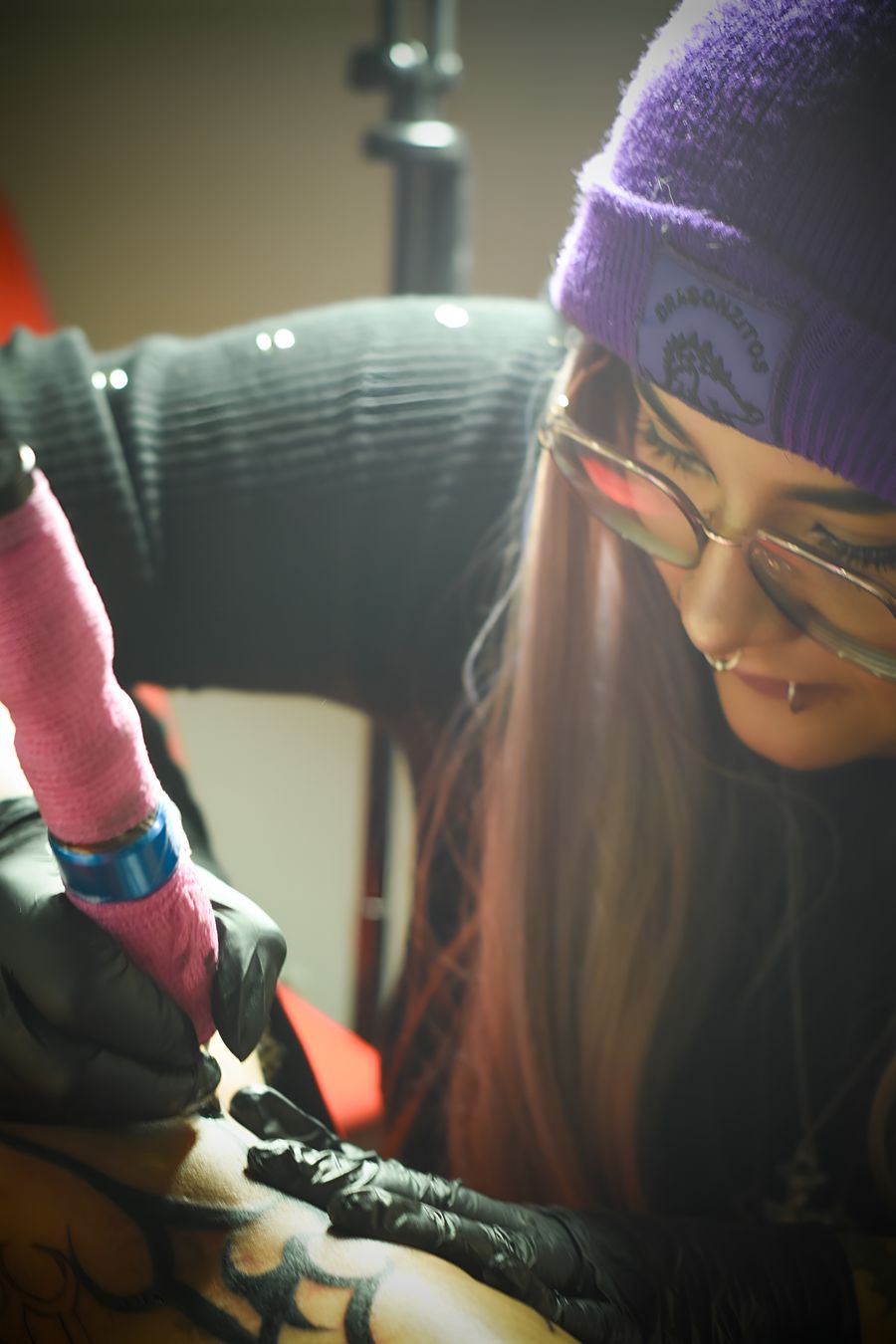Tattoo artist working with a client
