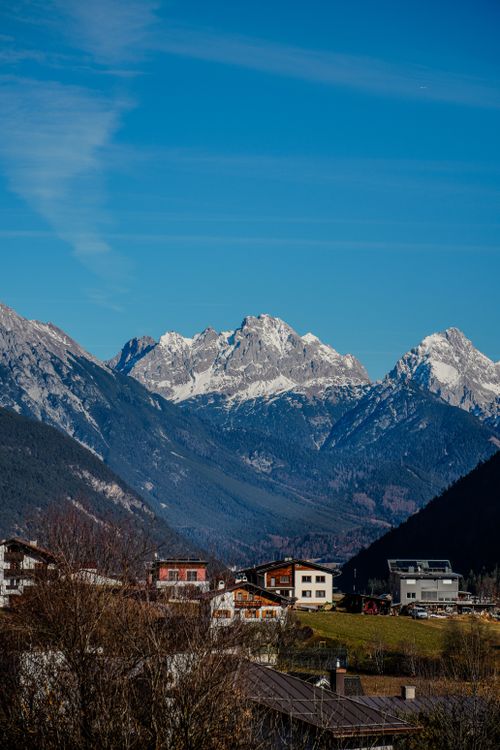 Free Idyllic view of a Tyrolean village with stunning snow-capped mountains in Austria. Stock Photo