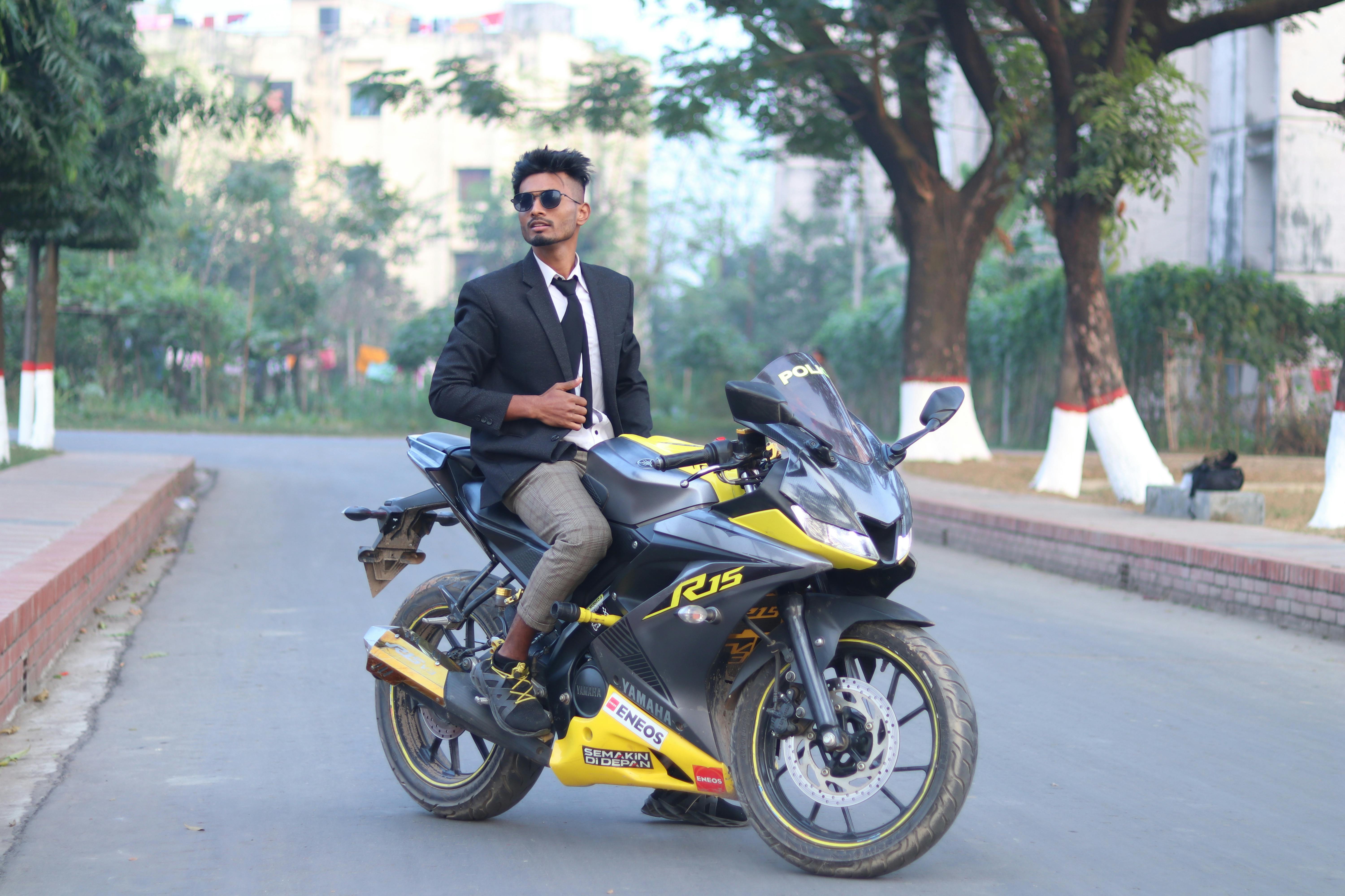 Безкоштовне Впевнений молодий чоловік у офіційному одязі позує на спортивному мотоциклі на міській дорозі. стокове фото