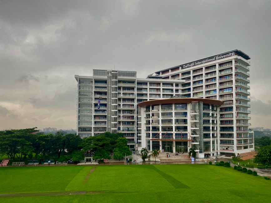 Modern architectural view of Daffodil International University with lush green surroundings in Dhaka.