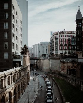 Capture of an urban street merging historical and modern architecture in overcast lighting.