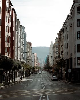 Urban street scene with tall buildings and a clear path under a bright sky.