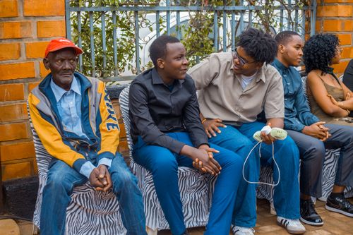 Free Diverse group of people sitting casually outdoors on a bench, engaging in conversation. Stock Photo