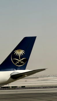 Airplane tail with logo on runway, showcasing aviation travel theme.