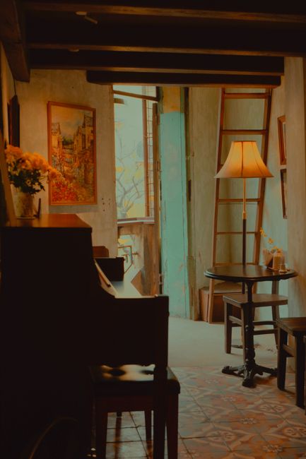A cozy café in Hanoi with a warm, inviting atmosphere featuring a piano and ambient lighting.