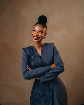 Charming portrait of a smiling woman in a stylish, elegant outfit against a warm background.