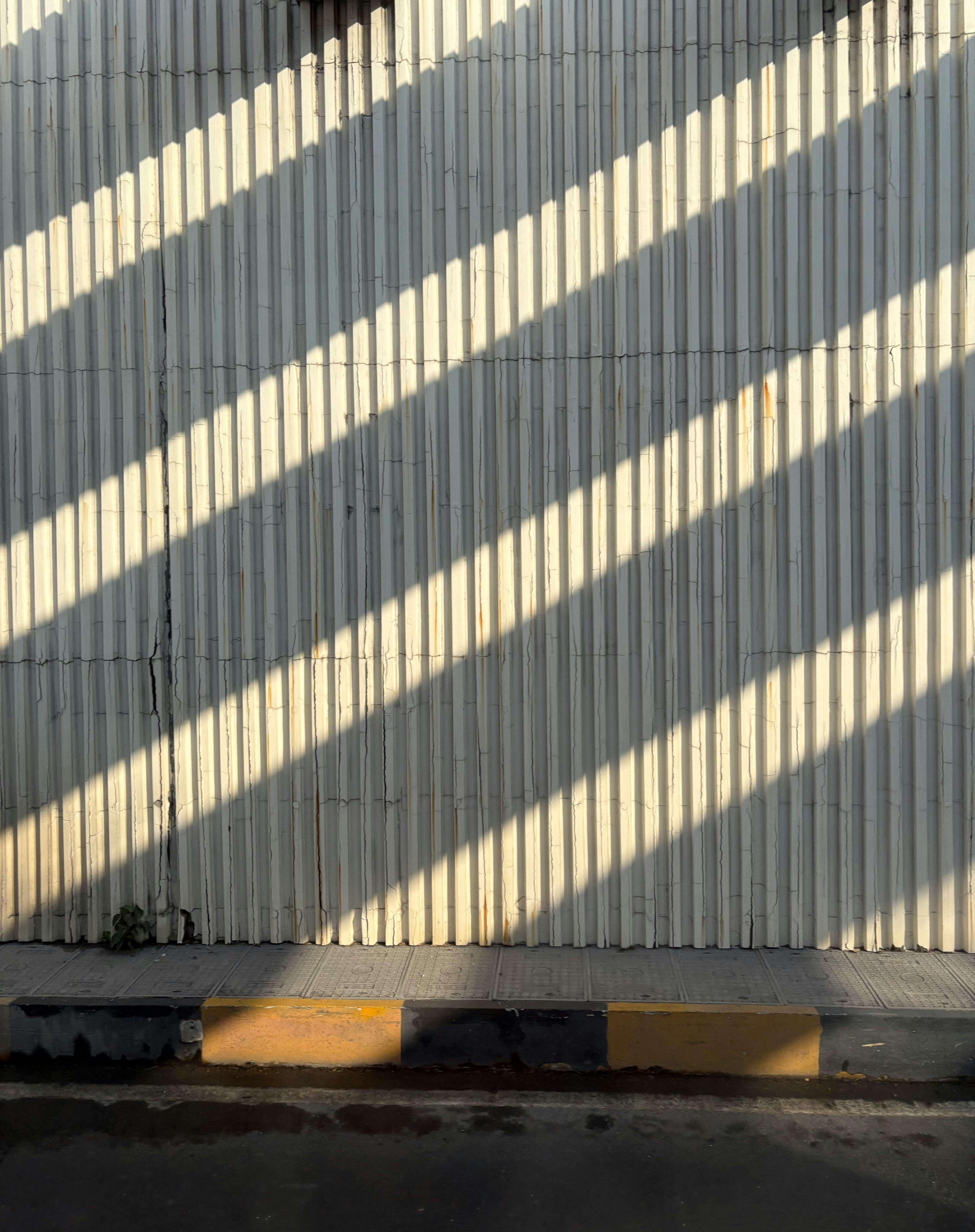 Kostenlos Diagonale Schatten, die auf eine Betonwand geworfen werden, erzeugen Tiefen- und Mustereffekte. Stock-Foto