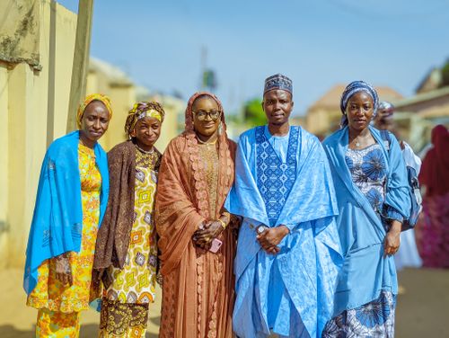 Free A group of people in colorful traditional Hausa attire posing outdoors on a sunny day. Stock Photo