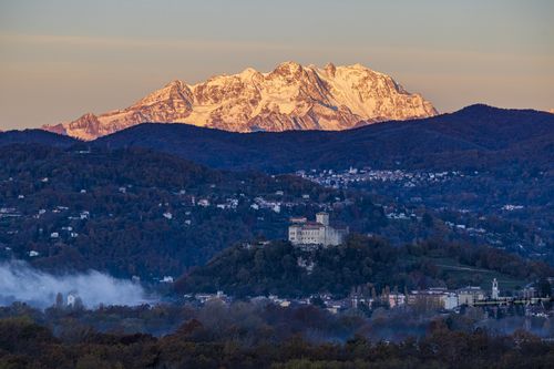 Free Mesmerizing view of snow-capped mountains and a historical castle during a serene dawn. Stock Photo