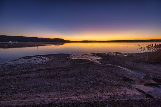 A breathtaking sunset view over a tranquil lake with a beautiful sky reflecting on the water.