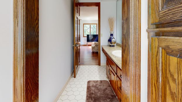 An elegant view through a hallway with wooden accents into a cozy living room with natural light.