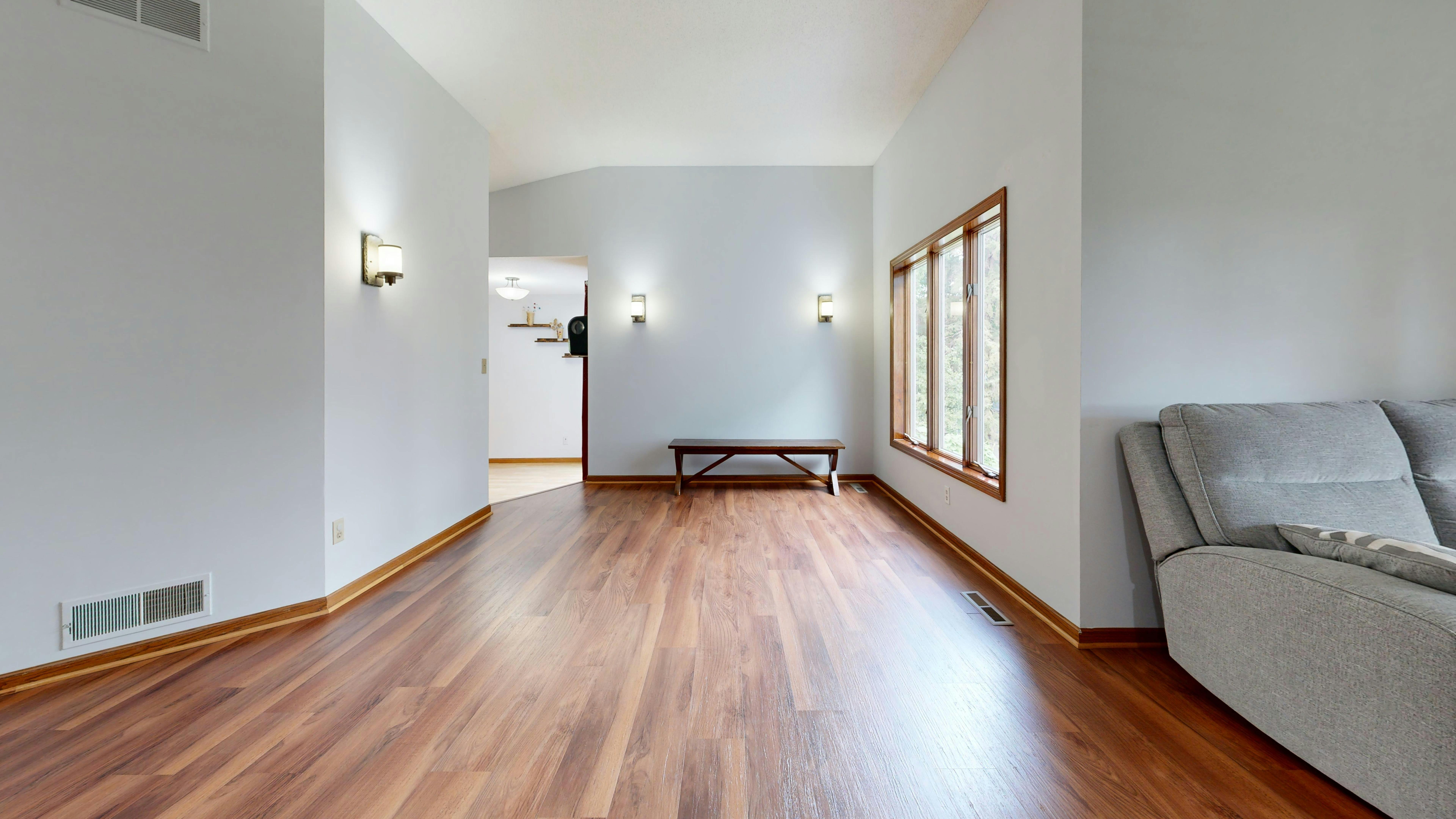 Helle Sockelleisten an einer weißen Wand mit Holzfußboden, sauberer Abschluss im modernen Wohnraum