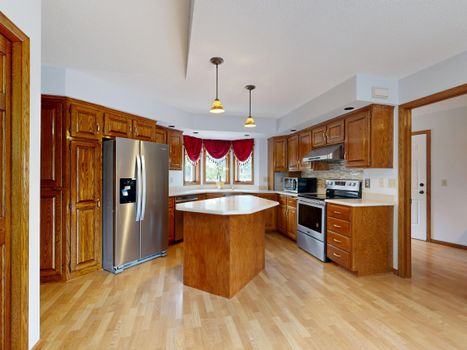 Beautiful kitchen with wooden cabinets, center island, and stainless steel appliances.