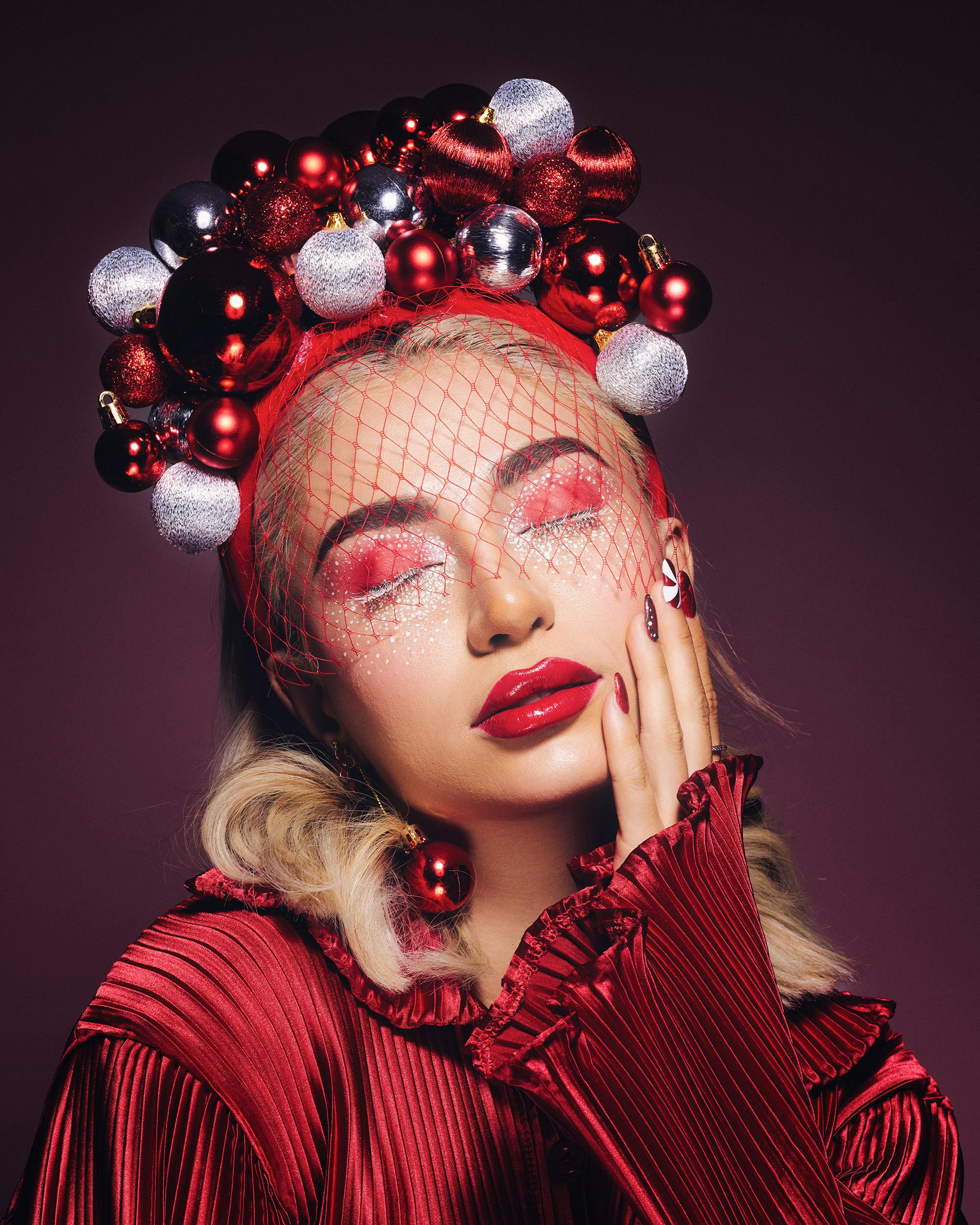 Gratis Elegante retrato con temática navideña que presenta a una mujer con maquillaje festivo y decoraciones navideñas. Foto de stock