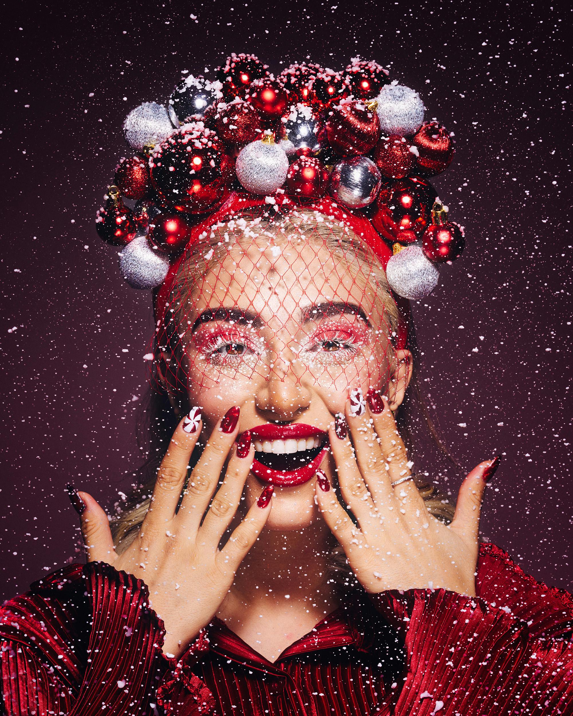 Gratis Mujer alegre con adornos rojos y plateados en retrato con temática navideña. Foto de stock