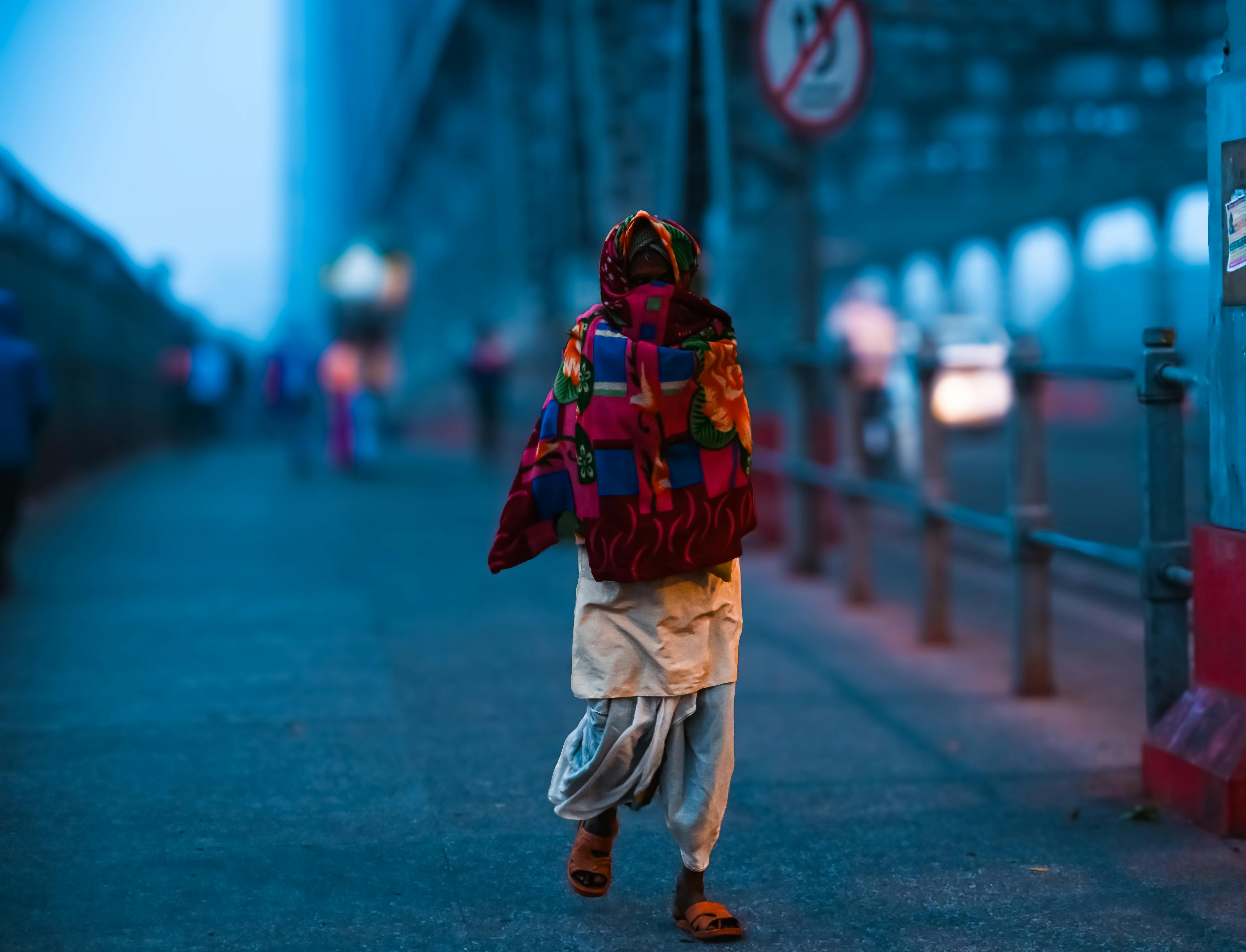 Zadarmo Človek sa prechádza po moste v Kalkate, zahalený v žiarivom šále, počas hmlistého zimného rána. Fotka z fotobanky