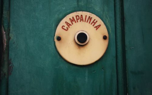 Free Close-up of a vintage doorbell with 'Campainha' text on a rustic green background. Stock Photo