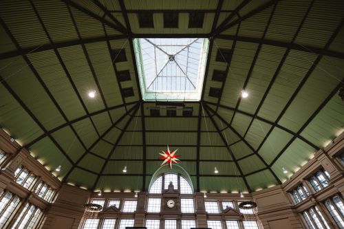 Free Interior view of a spacious hall with a glass ceiling and a hanging red star decoration. Stock Photo