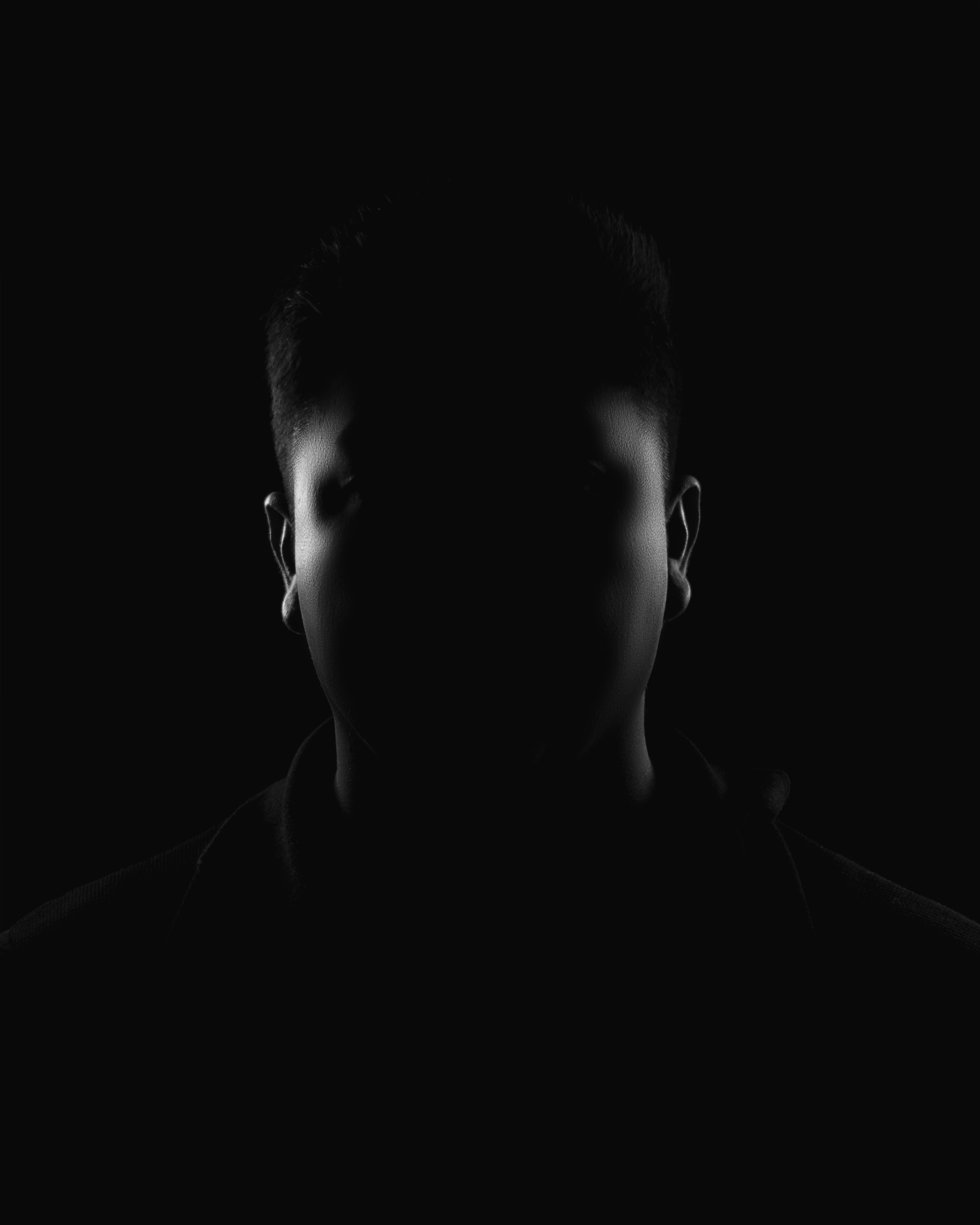 Silhouette of a person in darkness, emphasizing mystery and anonymity.