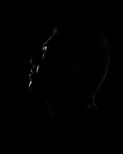 Profile silhouette of a person in deep shadow — photo by Zoe Galarza on Pexels