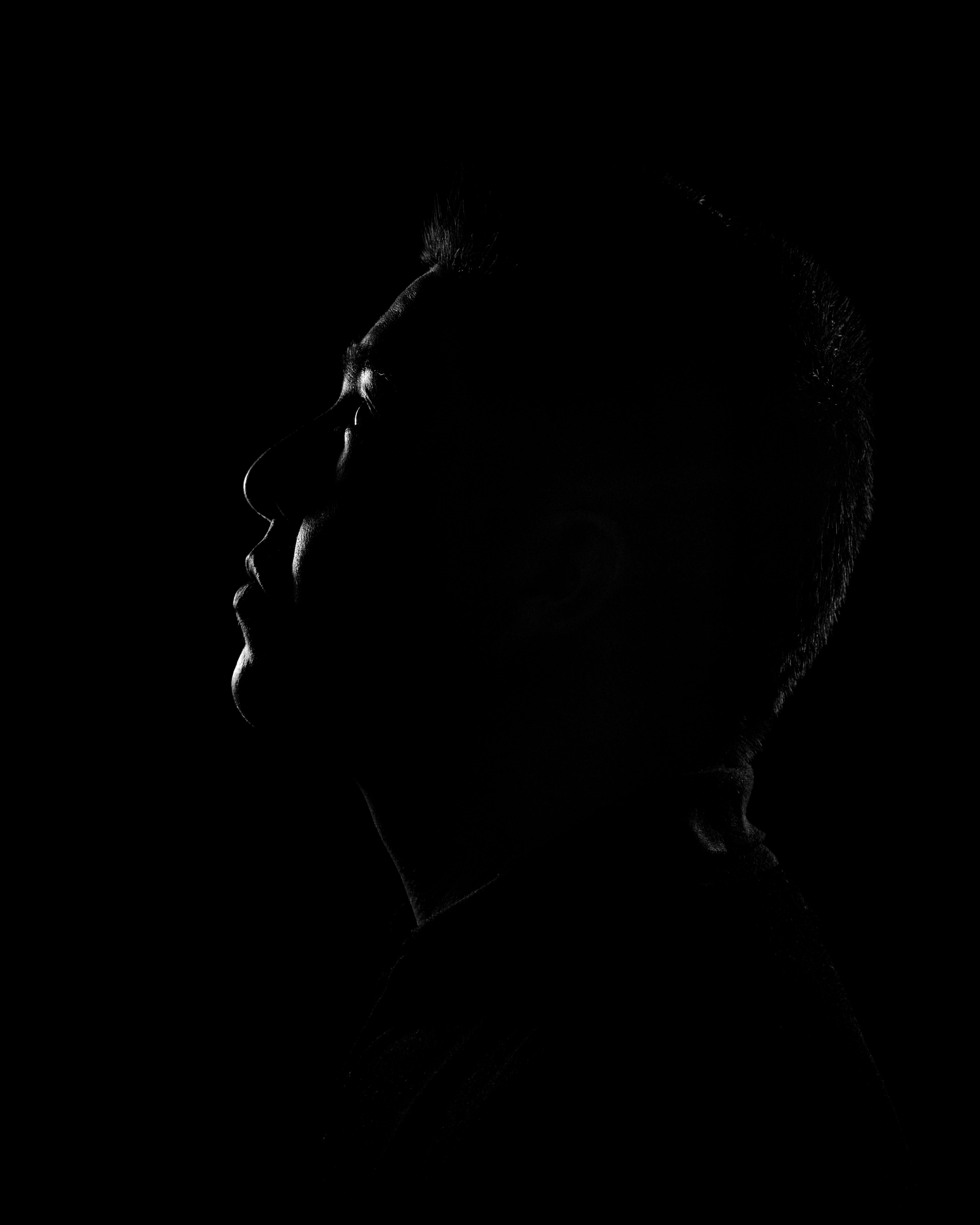 Gratis Kunstnerisk silhuettprofil av en person i skygge, som påkaller mystikk og introspeksjon. Arkivbilde