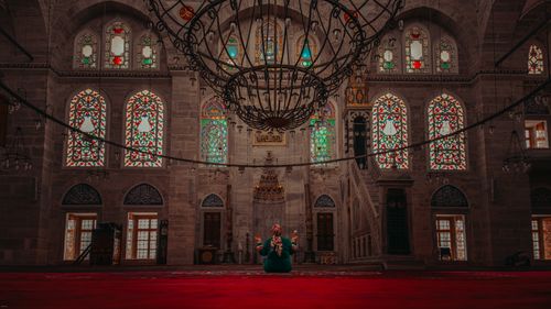 Free A person meditates in a beautifully illuminated mosque in Istanbul with stained glass windows. Stock Photo