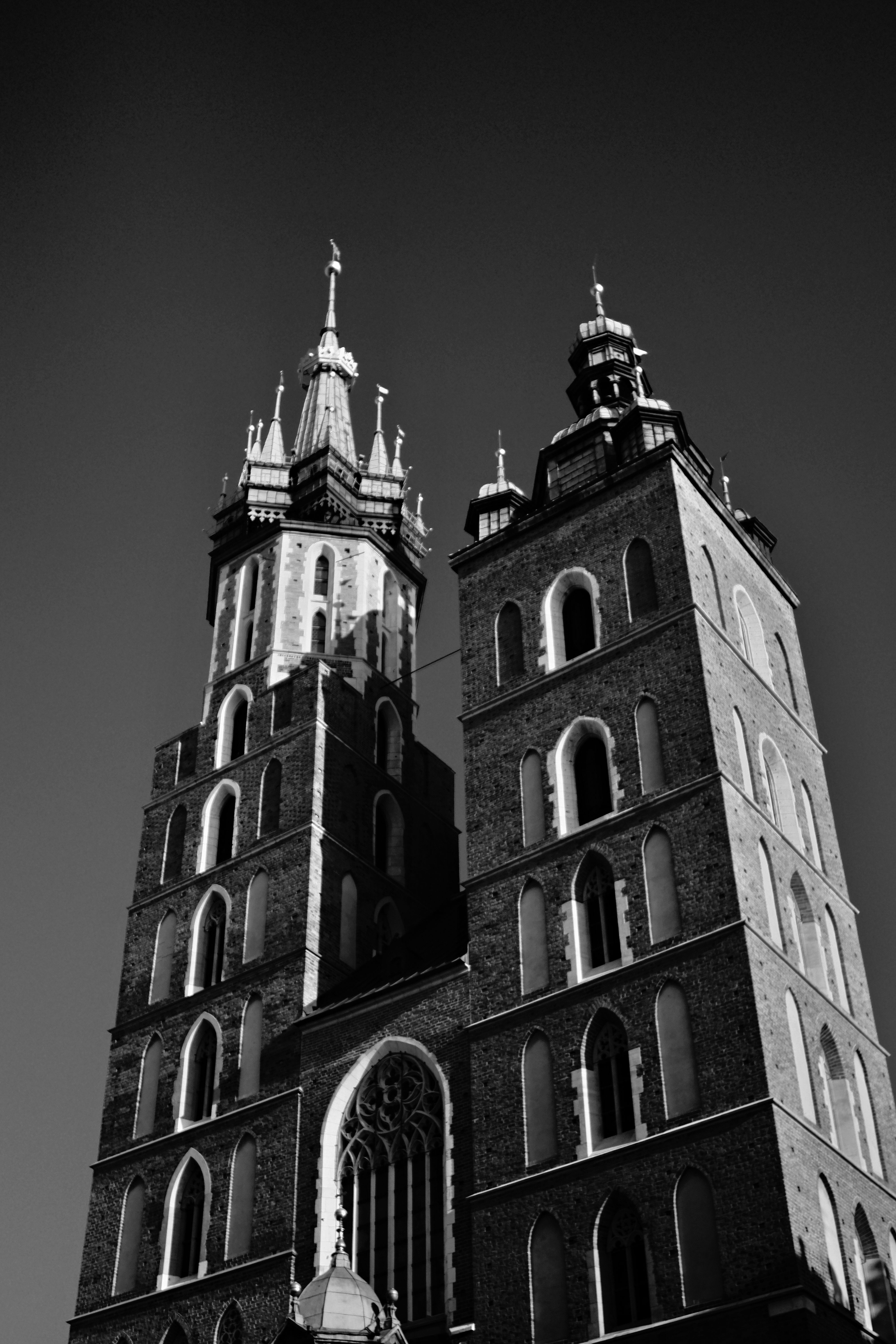 Dramatic black and white photo of St. Mary's Basilica's Gothic towers in Kraków.