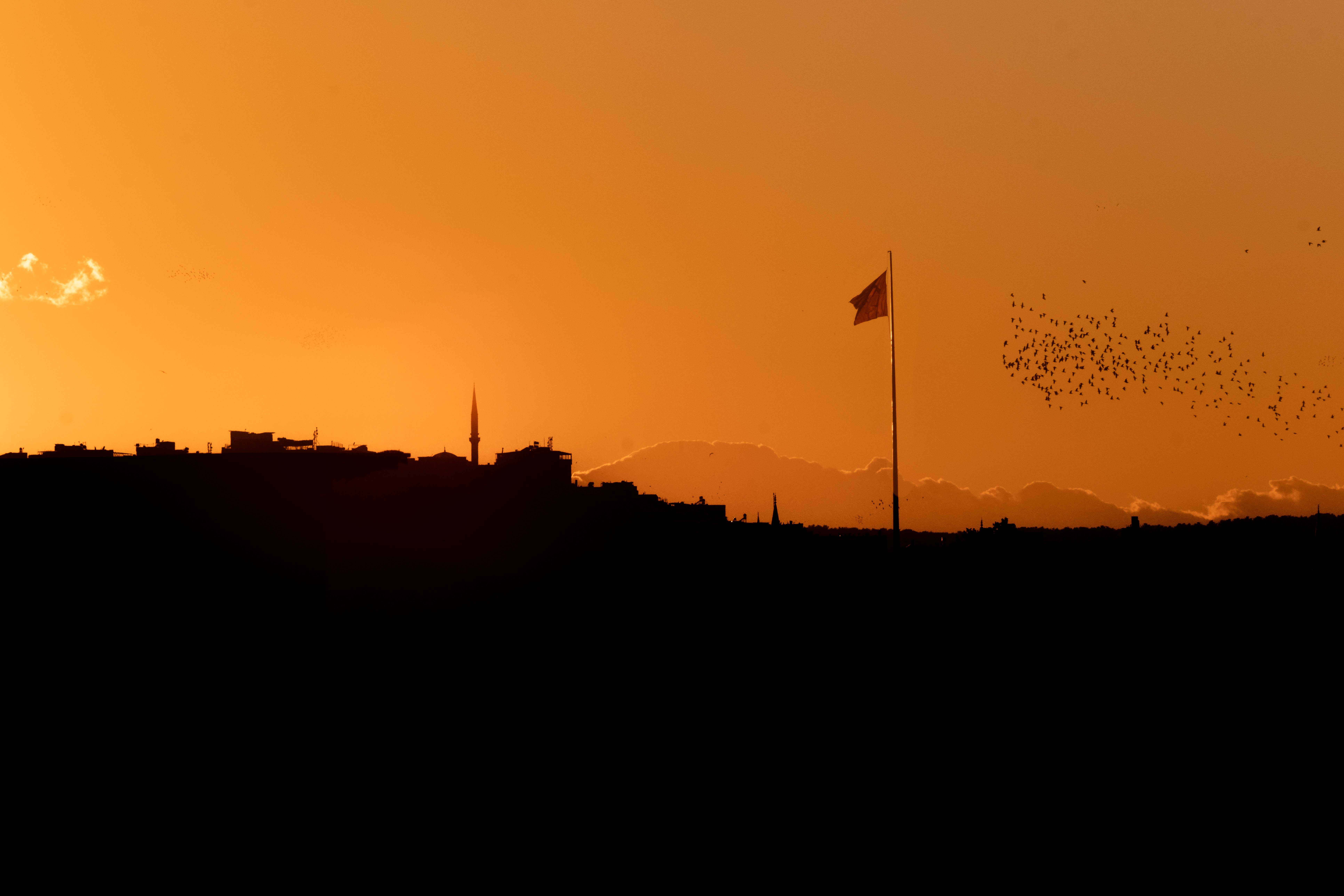 Sunset Silhouette over Urban Skyline with Flag · Free Stock Photo