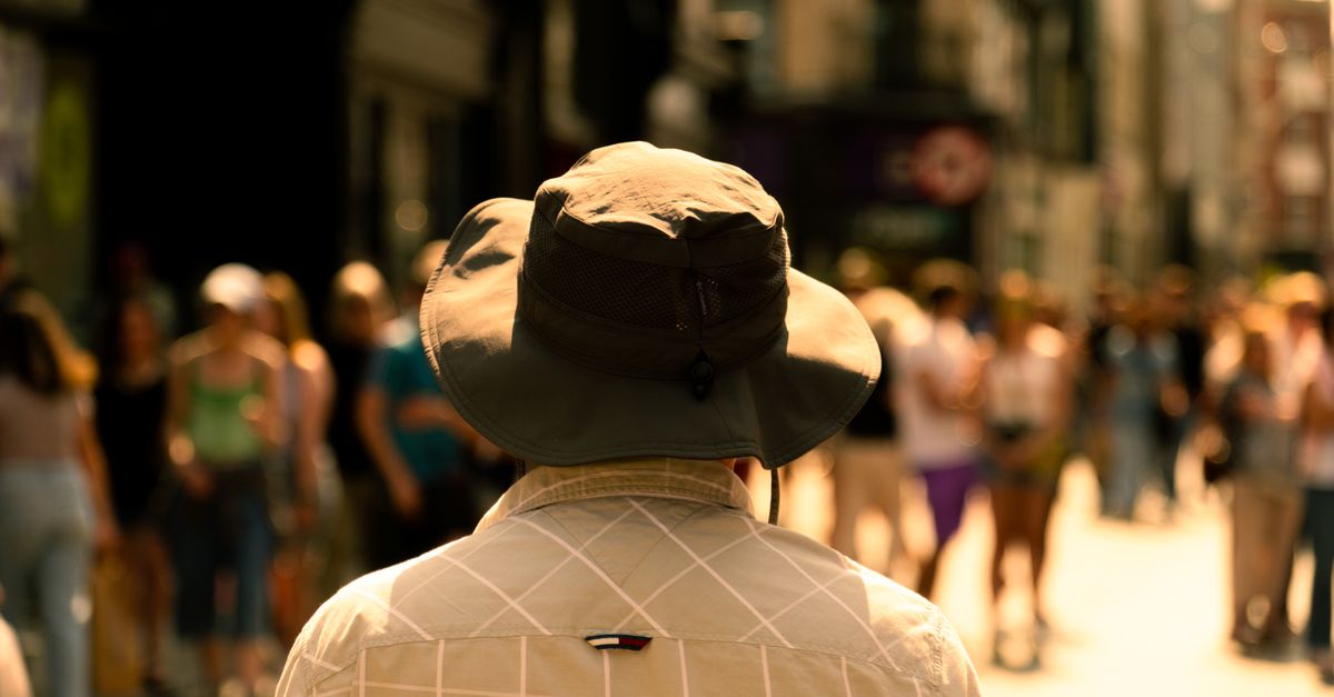 person sitting alone in a crowded city street, looking isolated