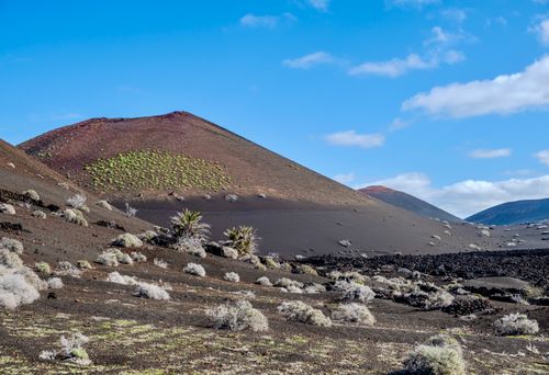 Free Barren volcanic terrain of Timanfaya National Park in Lanzarote, Spain under vivid blue skies. Stock Photo