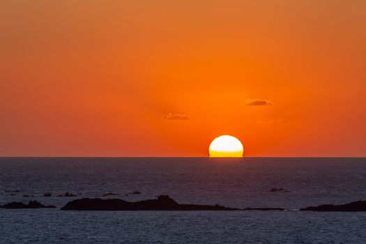 Vibrant sunset over the sea off the Brittany coast in France with a dramatic sky and calm ocean.