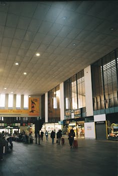 A bustling indoor train station with people and shops captured in vivid detail.