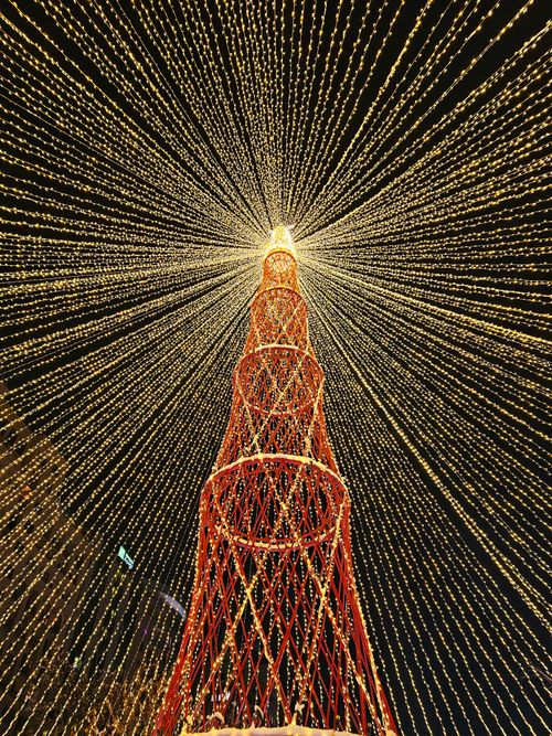 Free Breathtaking view of a towering Christmas tree with dazzling light decorations creating a radiant pattern. Stock Photo
