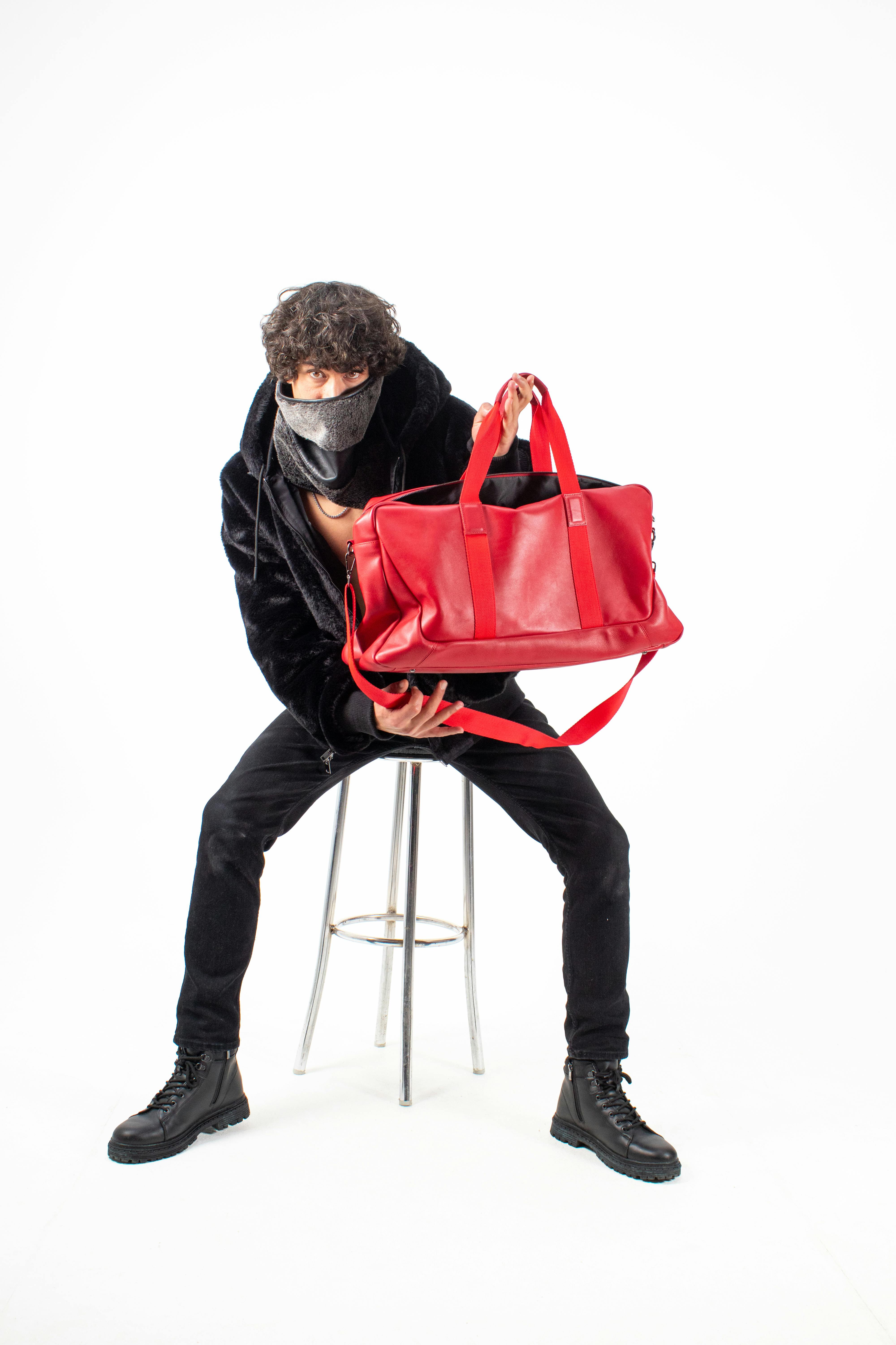 Gratis Stilig motemodell poserer med en livlig rød veske i et fotostudio. Arkivbilde