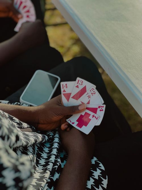 Free Close-up of hands holding unique playing cards outdoors, capturing a moment of leisure. Stock Photo