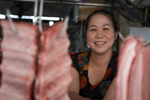 A cheerful woman stands in a bustling meat market, capturing the vibrant energy of Ho Chi Minh City.