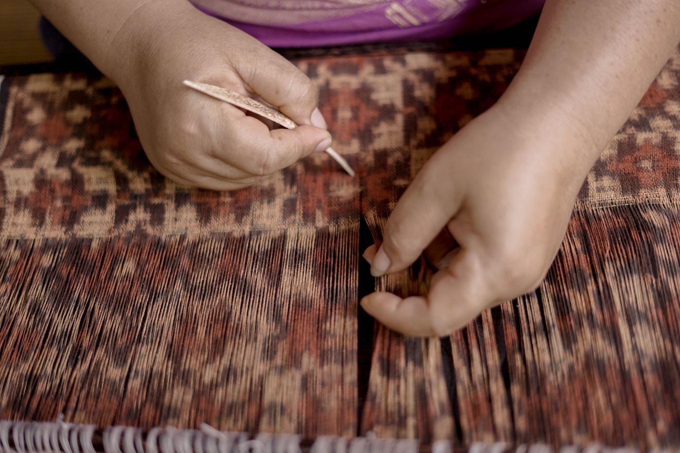 Traditional resist-dyed weaving in progress on a loom