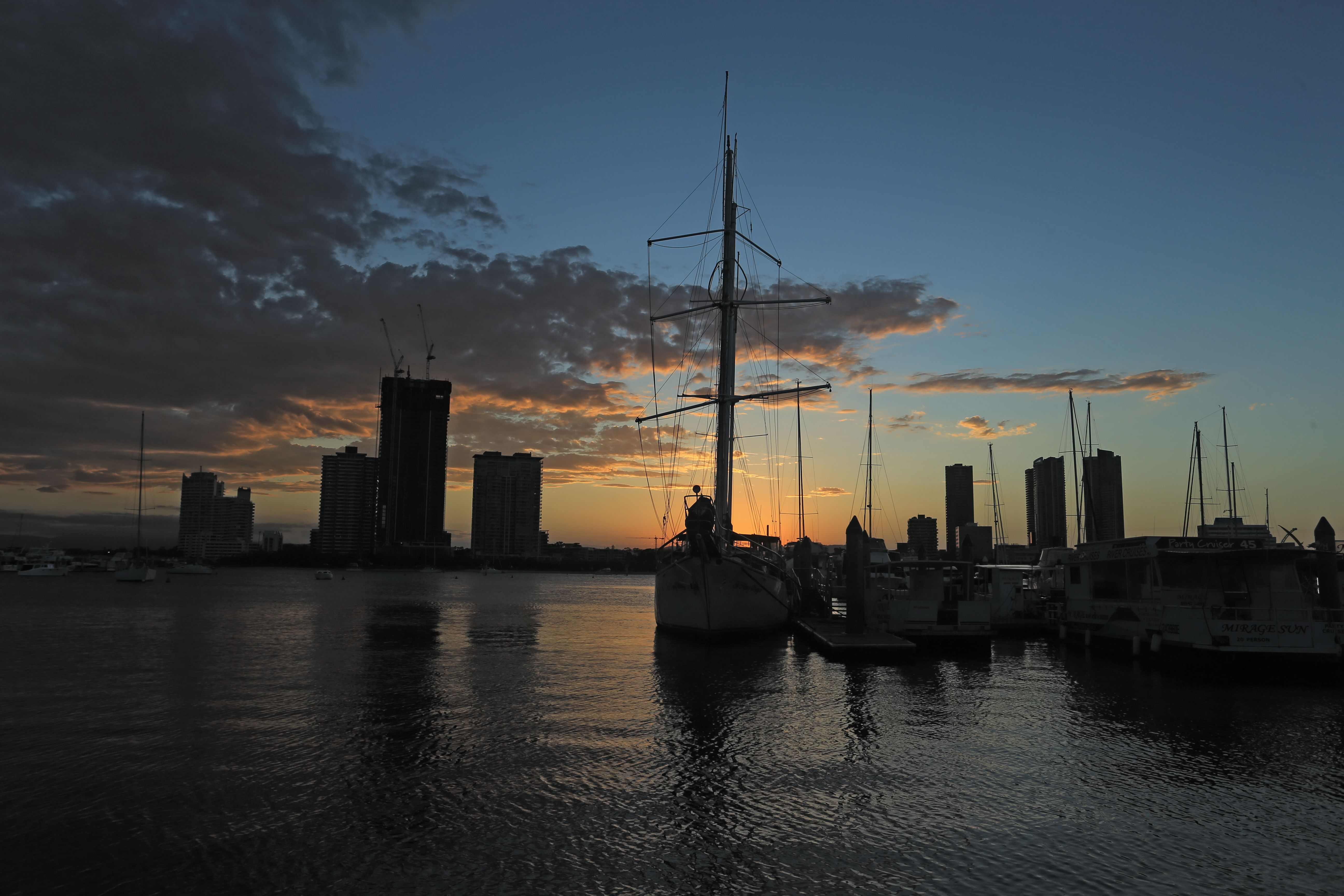 Scenic Sailboat Silhouette at Sunset over Urban Skyline · Free Stock Photo