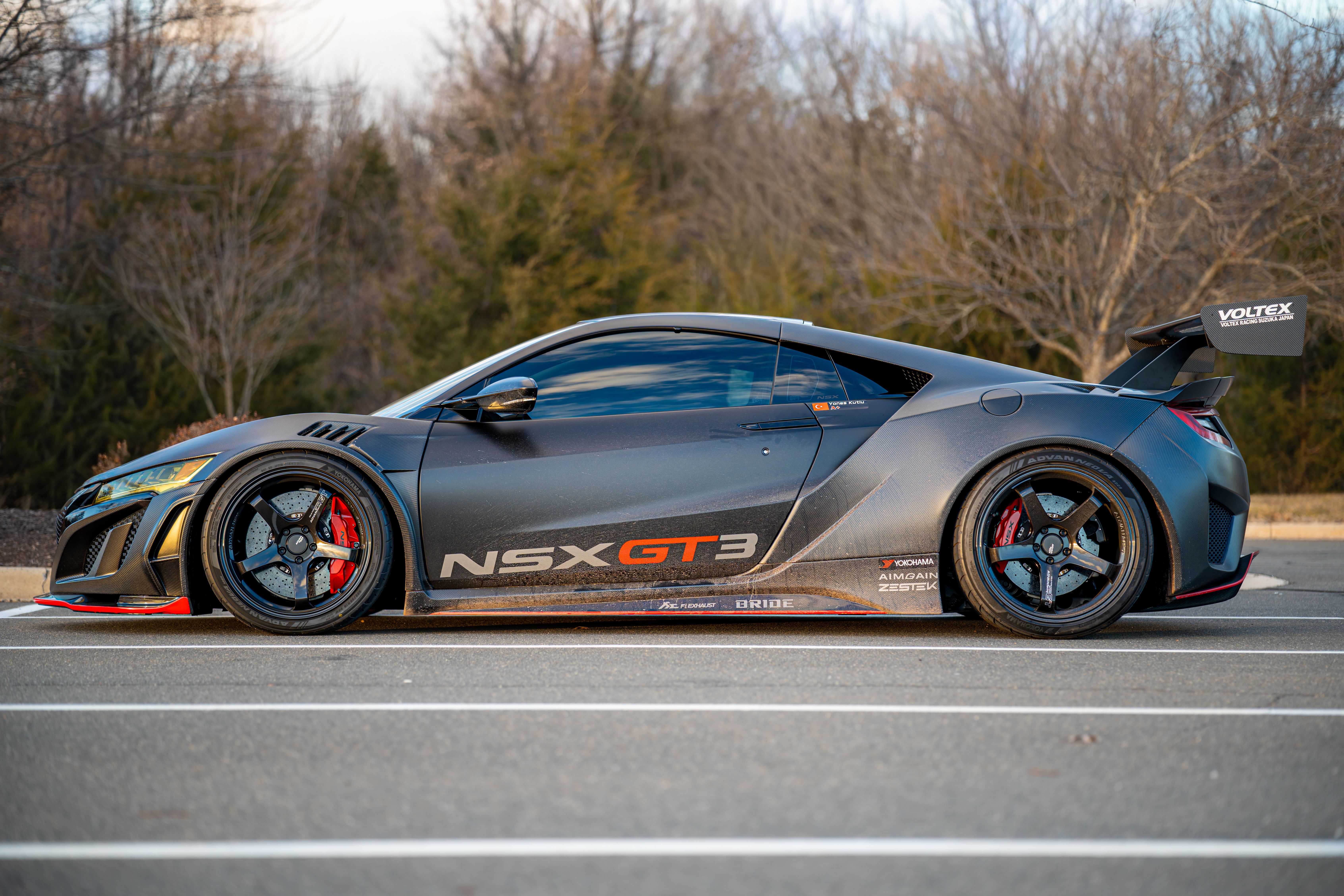 Stunning side view of a custom NSX GT3 racecar parked outdoors, showcasing aerodynamic design.