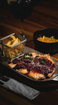 Savor this gourmet Colombian meal featuring seasoned chicken, fries, and garnish, perfect for a food lover.