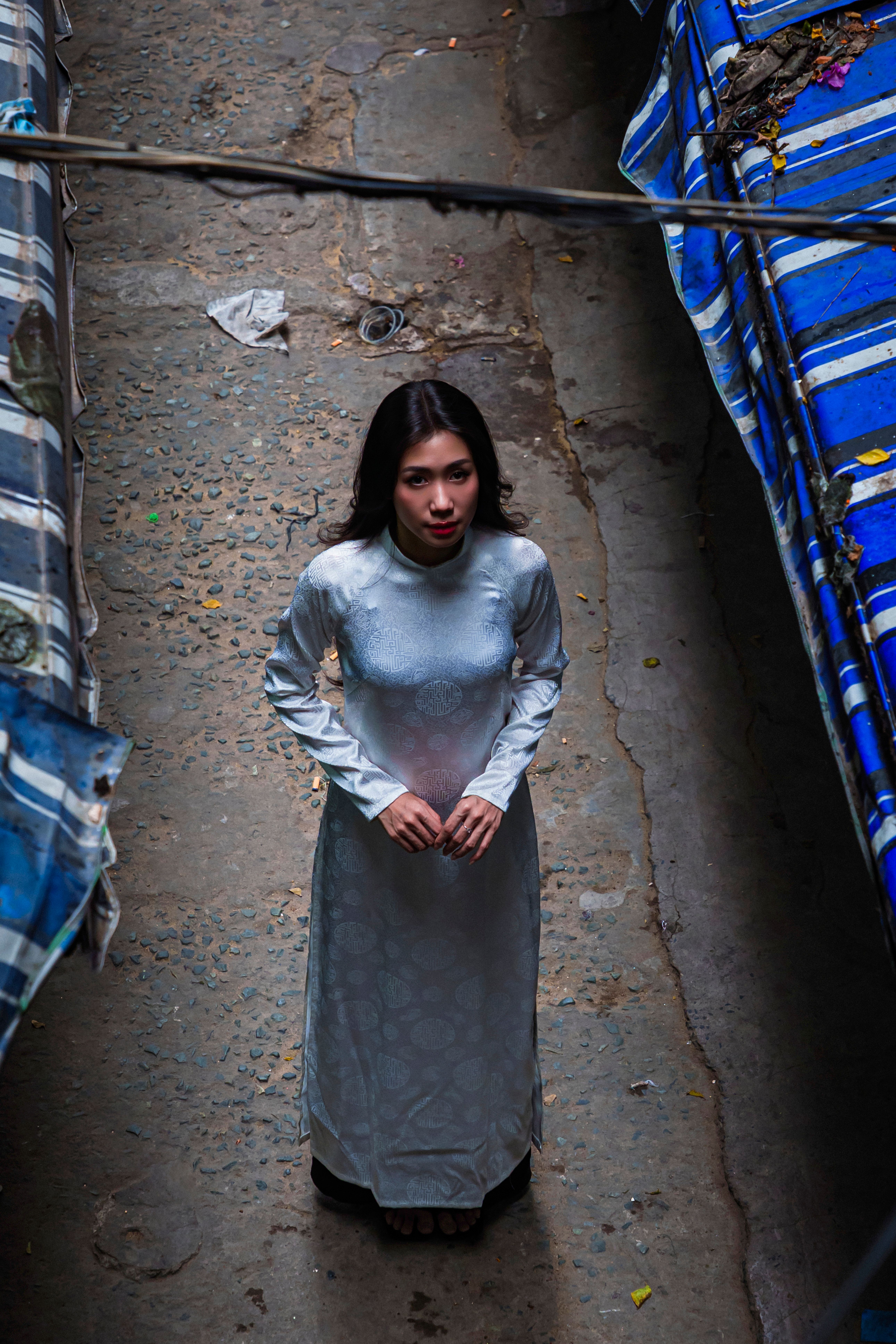 A woman in a traditional dress looks up indoors, captured from above.