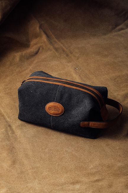 Elegant canvas toiletry bag featuring leather accents, perfect for travel and daily use.