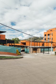 A view of modern urban construction site with orange brick buildings under a blue sky.