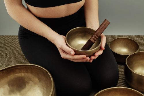 Free Close-up of a person using Tibetan singing bowls for meditation indoors. Stock Photo